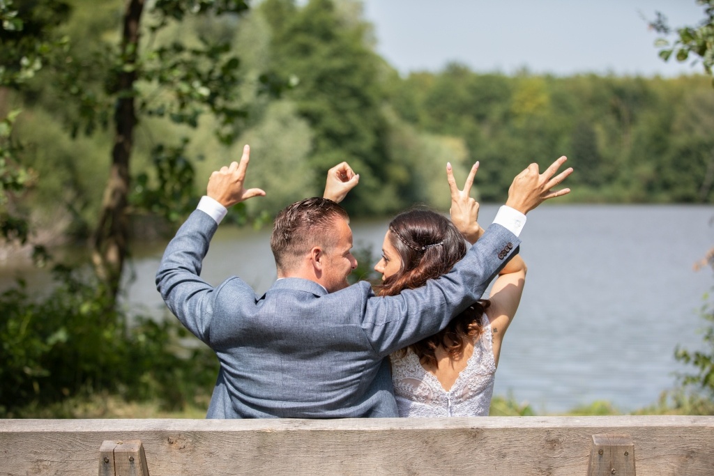 Bankje met bruidspaar en vormen de letters LOVE met de handen