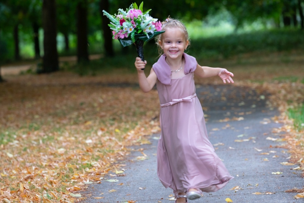 Meisje rent met boeket bij fotoshoot tijdens bruiloft